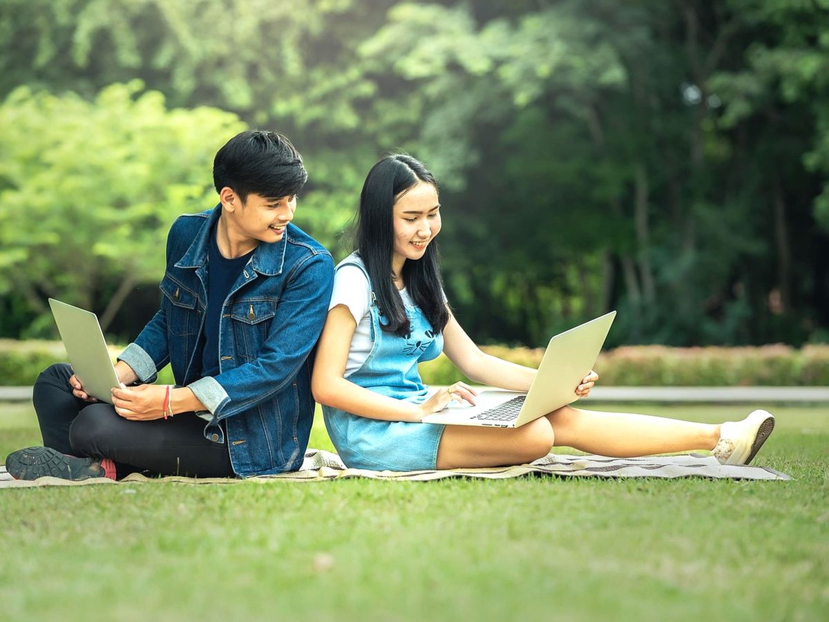 Siswa belajar dengan laptop di ruang kelas yang terang